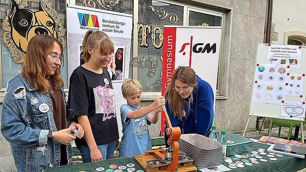 Buttons selber pr&auml;gen bei ",Markt und M&auml;rkte" am gemeinsamen Stand des Berufbildungszentrums und des Gymnasiums: Der Reingewinn der Aktion geht an die Ukrainehilfe. Foto: Margot D&ouml;rr