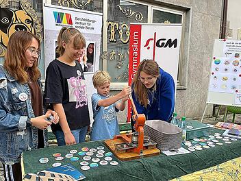 Buttons selber prägen bei ",Markt und Märkte" am gemeinsamen Stand des Berufbildungszentrums und des Gymnasiums: Der Reingewinn der Aktion geht an die Ukrainehilfe. Foto: Margot Dörr