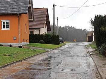 Diese Ortsstraße soll im Rahmen der Dorferneuerung saniert werden. Im Hintergrund das Ortsschild in Richtung Horbach. Direkt an die vorhandene Ortsbebauung soll sich das neue Baugebiet Schleifwegäcker anschließen.