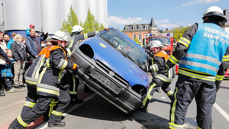 Was die Rettungskräfte leisten müssen, wenn es zu schweren Unfällen kommt, zeigten Feuerwehr, Rotes Kreuz und Polizei bei mehreren Schauübungen. Hier wird ein Kleinwagen nach einem Überschlag mit reiner Muskelkraft wieder auf die Räder gestellt. Neun Feuerwehrleute packen daüfr mit an. Foto: Matthias Hoch