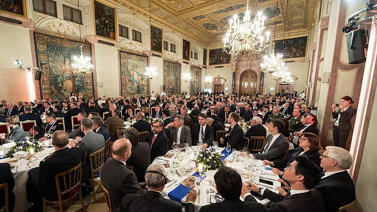 Zahlreiche Gäste der Sicherheitskonferenz sitzen auf einem Empfang während der Münchner Sicherheitskonferenz in der Residenz in München. Foto: Matthias Balk/dpa