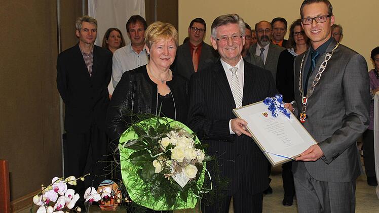 Bürgermeister Bezold (r.) ehrt seinen Vorgänger Gerhard Schmitt und beschenkt dessen Frau mit einem Blumenstrauß.  Foto: fra-press
