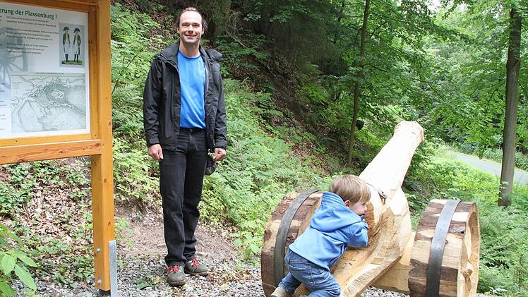 An die Belagerung der Plassenburg im Jahr 1806 erinnern zwei Kanonen auf dem Naturlehrpfad im Rehbergwald, die Michael Schütt geschaffen hat. Der Bindlacher Holzkünstler freut sich darüber, dass seine Werke bei den Kindern ankommen. Fotos: Peter Müller