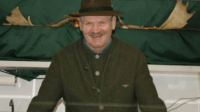 Immer für einen Scherz zu haben: Karl Jäger platziert sich lachend unter das Damwild-Geweih, das seinen Stand ziert. Foto: sw