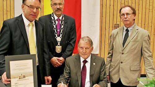 Harald Bötsch, Arthur Stollberger und Franz Hillenbrand (von links) tragen sich ins Goldene Buch der Gemeinde ein.