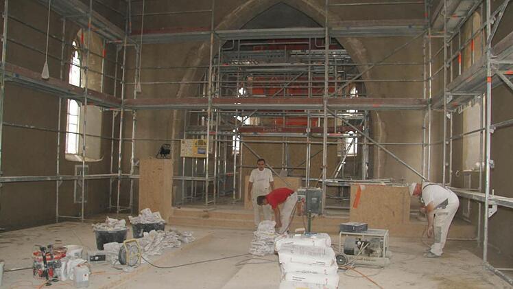 Der Hauptraum ist schon mit neuem Putz ersehen - jetzt machen sich die Arbeiter über den Kirchenraum, wo Altar und Orgel stehen. Foto: Sonja Adam