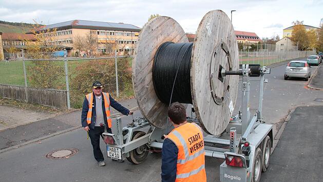 In Sichtweite des Frobenius-Gymnasiums (im Hintergrund) ziehen Mitarbeiter der Hammelburger Stadtwerke Glasfaser-Leitungen ein. Die Schulen k&ouml;nnen die Gigabit-Anschl&uuml;sse bereits nutzen. Foto: Ralf Ruppert
