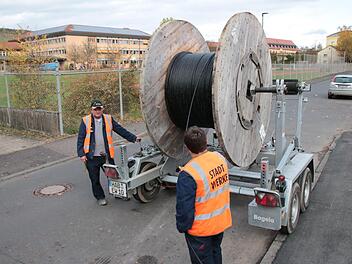 In Sichtweite des Frobenius-Gymnasiums (im Hintergrund) ziehen Mitarbeiter der Hammelburger Stadtwerke Glasfaser-Leitungen ein. Die Schulen können die Gigabit-Anschlüsse bereits nutzen. Foto: Ralf Ruppert