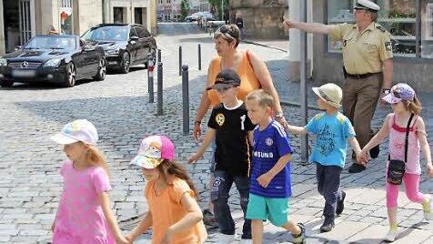 Polizist Andreas Müller zeigt einer Gruppe des Kindergartens Steinwiesen, wie man einen Zebrastreifen überquert.  Foto: Andreas Schmitt
