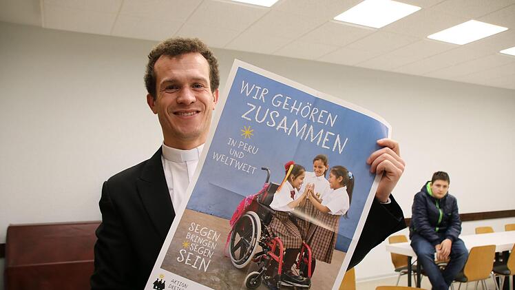 Pfarrvikar Michael Schmitt zeigt das Plakat der diesjährigen Aktion: Kinder mit Behinderung sowie das Land Peru stehen im Mittelpunkt.