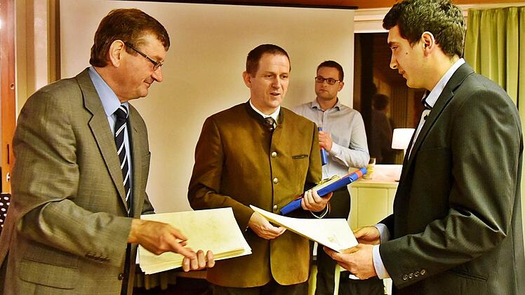 Hans Vetter und Rainer Mattern gratulieren dem Prüfungsbesten Christoph Paschold zur Abschlussprüfung als Landwirt. Foto: Gabi Arnold