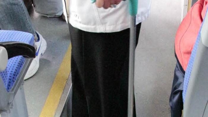 Diese Frau muss sich mit ihren Gehhilfen quer durch den engen Gang quälen.