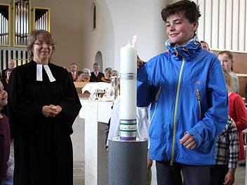 Die Osterkerze in der evangelischen Kirche von Herzogenaurach wird angezündet. Sie ruht in einem neuen Leuchter.  Fotos: Richard Sänger