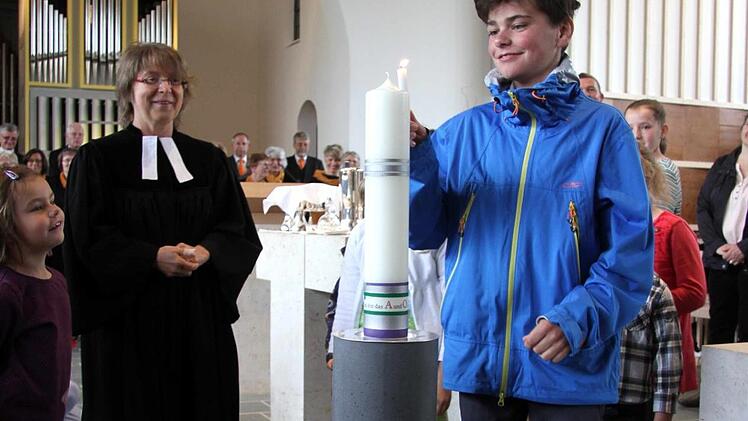 Die Osterkerze in der evangelischen Kirche von Herzogenaurach wird angezündet. Sie ruht in einem neuen Leuchter.  Fotos: Richard Sänger