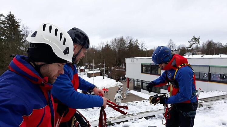 Gemeinsam mit einer Gruppe von Gebirgsjägern haben Helfer der Bergwachtbereitschaft Kulmbach-Obermain das Dach einer Schule vom Schnee befreit. Foto: Bergwacht