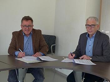 Jetzt kann es los gehen: Die Stadtwerke Hammelburg versorgen Wasserlosen mit Glasfasertechnik. Stephan Dausacker (Stadtwerke) und Bürgermeister Anton Gößmann unterschrieben den Vertrag im Greßthaler Rathaus. Foto: Hans-Peter Heppp