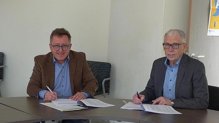 Jetzt kann es los gehen: Die Stadtwerke Hammelburg versorgen Wasserlosen mit Glasfasertechnik. Stephan Dausacker (Stadtwerke) und Bürgermeister Anton Gößmann unterschrieben den Vertrag im Greßthaler Rathaus. Foto: Hans-Peter Heppp