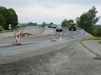 Jetzt fließt der Verkehr zügig über die neue Brücke zwischen Melkendorf und Katschenreuth. Die bisherige Engstelle bei der alten Sandsteinbrücke (links) gehört der Vergangenheit an. Foto: Dagmar Besand