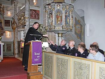 Pfarrer Wolfgang Oertel überreichte den Mitgliedern der Feuerwehr die Attribute, die einst auf dem Untersteinacher Kirchturm waren: ein Hahn und eine Sonne. Foto: Sonny Adam
