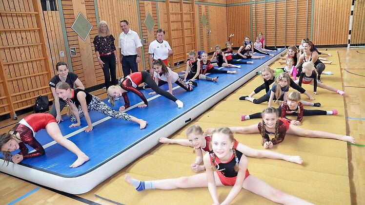 Den Turnmädels des TVU macht das Training jetzt noch mehr Spaß. Hochmotiviert zeigen sie ihre neue "Airtrack- Matte", mit dabei die stellvertretende Schulleiterin der GS Rodachtal, Karin Hader und Bürgermeister Norbert Gräbner (stehend) sowie die 2. TVU-Vorsitzende, Sylvia Hanke (auf der Matte kniend links). Foto: K.- H. Hofmann