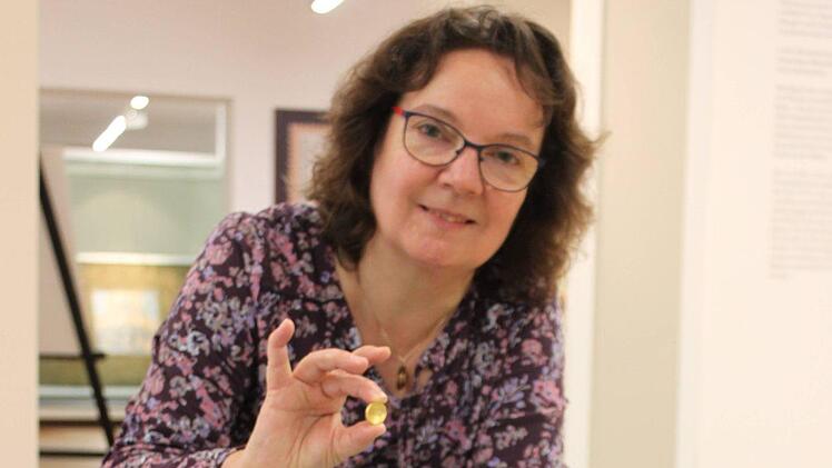 Museumspädagogin Christine Liebl mit dem "Goldstater", einem Fundstück mit Bezug zum Staffelberg.