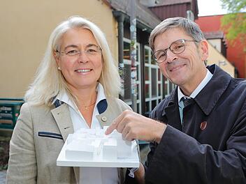 Uni-Kanzlerin Dagmar Steuer-Flieser und Jürgen König, Leiter des Staatlichen Bauamts Bamberg stehen vor alten Innenstadtmensa. In der Hand haben sie das Modell für den Neubau. Foto: Matthias Hoch
