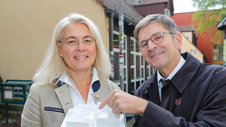 Uni-Kanzlerin Dagmar Steuer-Flieser und Jürgen König, Leiter des Staatlichen Bauamts Bamberg stehen vor alten Innenstadtmensa. In der Hand haben sie das Modell für den Neubau. Foto: Matthias Hoch