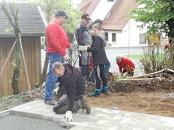 Einige fleißige Helfer beim Pflastern der Freifläche, vorne Reiner Lauterbach, der auch die Steine spendiert hatte. Foto: Klaus-Peter Wulf