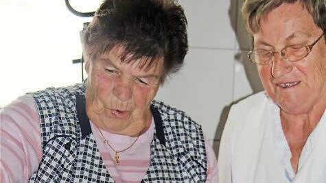 Elfriede Schneid (links) und Maria Bischoff streuen Schinken-"Bröckele" auf den Plootzteig.