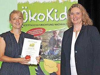 Staatsministerin Kerstin Schreyer (rechts) &uuml;berreicht Kindergartenleiterin Karin Vonbrunn die Urkunde. Foto: pr
