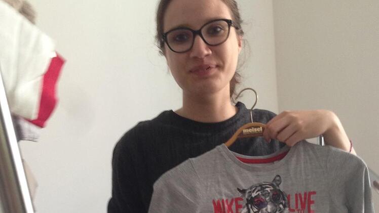 Lena Dillinger räumt die Kleiderkammer nach dem Umbau mit ein.