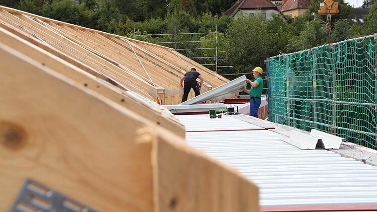 Zwei Bauarbeiter arbeiten in sechs Metern Höhe.