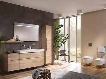Schrankmöbel aus Holz bringen immer eine sehr persönliche Note ins Ambiente und lehnen sich in ihrem Äußeren zunehmend an Modelle aus dem Wohnbereich an. Die Montage der Ablage neben statt unter dem Spiegel sorgt für das gewisse Extra.  Foto: Vereinigung Deutsche Sanitärwirtschaft (VDS), Keramag