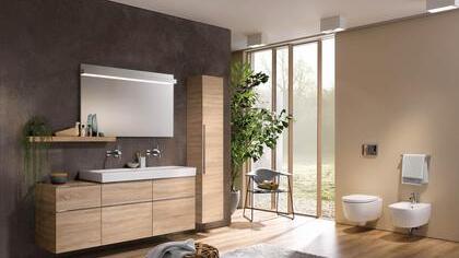 Schrankmöbel aus Holz bringen immer eine sehr persönliche Note ins Ambiente und lehnen sich in ihrem Äußeren zunehmend an Modelle aus dem Wohnbereich an. Die Montage der Ablage neben statt unter dem Spiegel sorgt für das gewisse Extra.  Foto: Vereinigung Deutsche Sanitärwirtschaft (VDS), Keramag