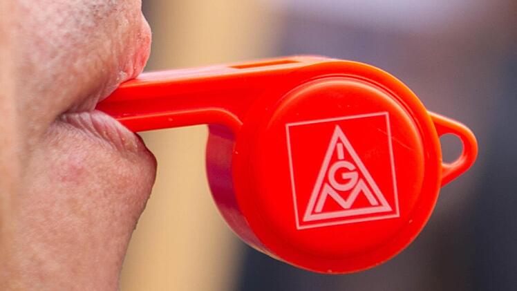 Ein Mitarbeiter von Bosch bläst am 02.05.2013 anlässlich eines Warnstreiks vor dem Robert Bosch Werk in Hildesheim (Niedersachsen) in seine Pfeife. Die IG Metall fordert 5,5 Prozent mehr Geld auf zwölf Monate. Foto: Sebastian Kahnert/dpa