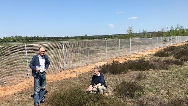 Ein formales Naturschutzgebiet auf dem Landeplatz soll nach Meinung des BN "weiteren "Zerst&ouml;rungen" einen Riegel vorlegen: Erich Spranger und Martin B&uuml;cker (rechts) vor dem Zaun, der den Flugplatz neuerdings  auf sechs Kilometern L&auml;nge umgibt.  Foto: M. Wehner