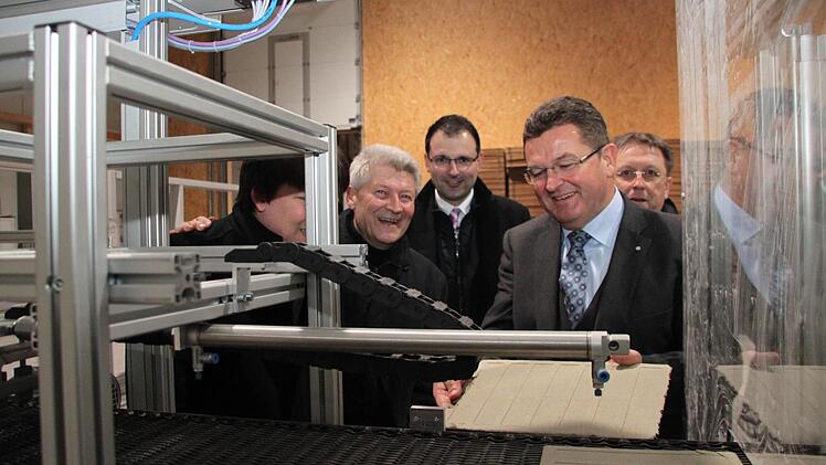 Staatssekretär Pschierer an der neuen Fertigungsanlage für die Mörtelplatten.