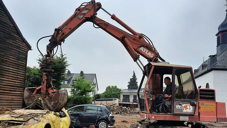 Eine Woche lang war Alfred Greubel mit seinem Bagger im Ahrtal unterwegs, um Flutschäden zu beheben, hier räumt sein Bekannter Reinhold Mall mit dem Bagger ein völlig zerstörtes Fahrzeug weg.