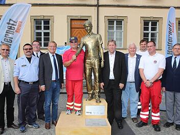 Vor dem Rathaus Maxplatz wurde die goldglänzende Statue von Vertretern der Stadt, des Landkreises und der Hilfsorganisationen präsentiert. Foto: Riegerpress