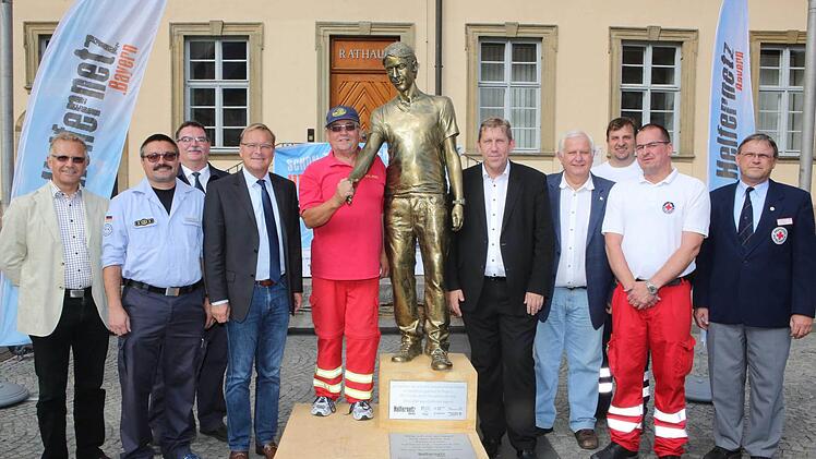 Vor dem Rathaus Maxplatz wurde die goldglänzende Statue von Vertretern der Stadt, des Landkreises und der Hilfsorganisationen präsentiert. Foto: Riegerpress
