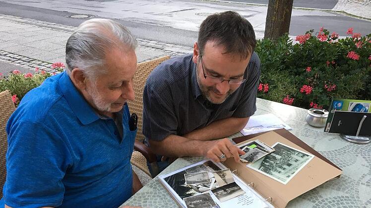 Ferdinand Kirmeier (links) zeigt dem Altstadtvereins-Vorsitzenden Oliver Schikora seine Bildersammlung mit historischen Ansichten Münnerstadts.Christine Schikora
