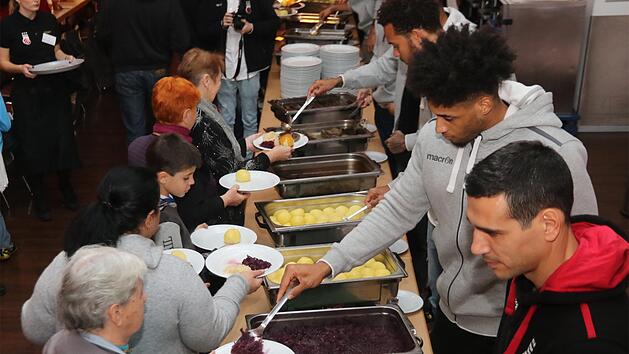 Die Basketballstars Elias Harris, Augustine Rubit und Nikos Zisis beweisen ihre Qualitäten als Servierkräfte. Foto: Bertram Wagner