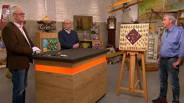 Der Bad Br&uuml;ckenauer Uwe Schindler (rechts) war zu Gast in der bekannten ZDF-Sendung "Bares f&uuml;r Rares". Hier ist er im Studio mit Moderator Horst Lichter (Mitte) und Experte Albert Maier (links) zu sehen - samt der von ihm mitgebrachten Schablonen. Screenshot: ZDF/Bares f&uuml;r Rares vom 19. Mai 2021; Rebecca Vogt