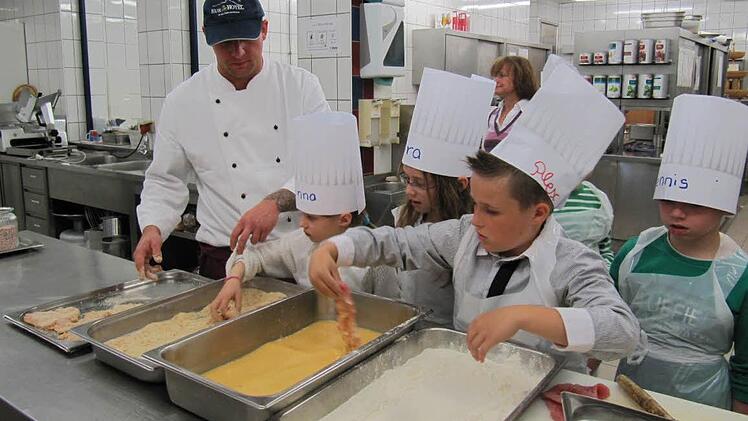 Koch Christian Popp gibt noch ein paar Tipps - den Rest machen die Grundschüler schon fast alleine.
