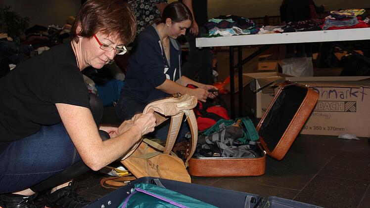 Ganze Koffer voller gespendeter Kleidung werden in der Heinrich-Lades-Halle ausgepackt. Foto: Max Kaltenhäuser