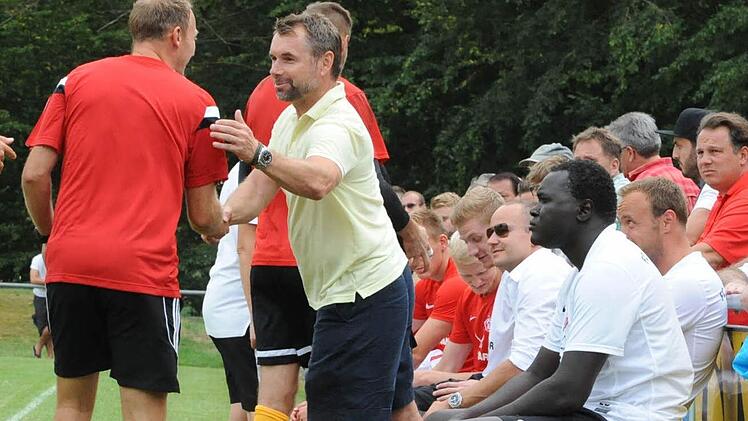 Ein freundlicher Gast - Bernd Hollerbach, Trainer der Würzburger Kickers, begrüßt beim Pokalspiel in Reichenbach Markus Bach. Foto: Hopf