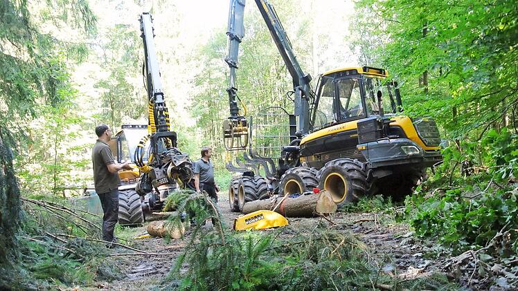 Kurze Reparatur des Harvesters (links), dann geht's weiter: Daniel Steuer und Günther Schneider (von links) vor Harvester und Rückezug. Zum Glück konnten die dringenden Arbeiten bei Fatschenbrunn erledigt werden. Jetzt ist man unterwegs Richtung Passau. Fotos: Brigitte Krause