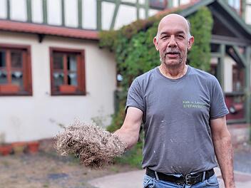 Stefan Mayer vor seinem renovierten Haus. In der Hand hält er Stopfhanf, den er auch zum Dämmen nutzt. Foto: Ellen Mützel