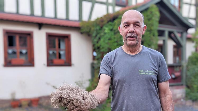 Stefan Mayer vor seinem renovierten Haus. In der Hand hält er Stopfhanf, den er auch zum Dämmen nutzt. Foto: Ellen Mützel