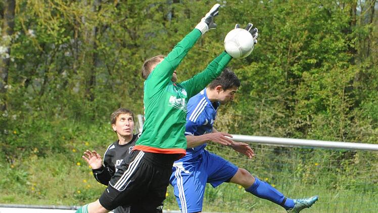 Ausgestreckte Arme schlagen langen Hals: Geesdorfs Keeper Torwart Philipp Seufert kommt vor Münnerstadts Adrian Reith ans Leder. Foto: Hopf